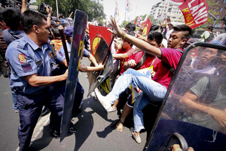 Philippine riot policemen fight with protestors during a demonstration calling for the abolition of the Visiting Forces Agreement in front of the US Embassy in Manila, Philippines, on March 24, 2009. [Xinhua/STR]