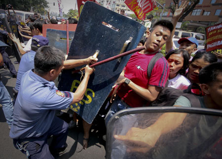  Philippine riot policemen fight with protestors during a demonstration calling for the abolition of the Visiting Forces Agreement in front of the US Embassy in Manila, Philippines, on March 24, 2009.[Xinhua/STR]