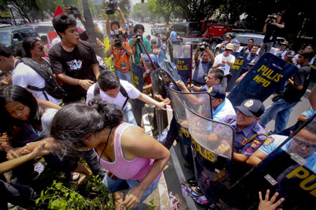  Philippine riot policemen fight with protestors during a demonstration calling for the abolition of the Visiting Forces Agreement in front of the US Embassy in Manila, Philippines, on March 24, 2009.[Xinhua/STR]