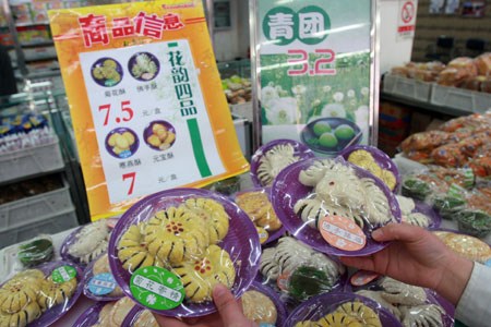 A shop employee shows the Qingming pastry at a Daoxiangcun store, in Beijing, capital of China, Mar. 24, 2009. Daoxiangcun, a time-honored foodstuff company in Beijing, produced a special pastry series for the upcoming Qingming Festival for Chinese people to pay respects to their ancestors. [Chen Xiaogen/Xinhua] 