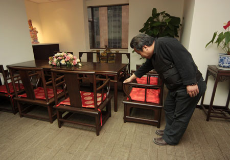 Photo taken in Beijing on March 23, 2009 shows a visitor looks at a set of the traditional Chinese furnitures which were used by Jacque Rogge, president of the International Olympic Committee (IOC), during his stay in the Beijing Hotel to work for the 2008 Olympic Games. Some 20 pieces of bamboo-made furnitures copying China's Ming Dynasty (1368-1644 A.D.) style are to be auctioned at the end of this March. [Wu Changqing/Xinhua] 