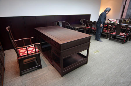 Photo taken in Beijing on March 23, 2009 shows a visitor looks at the traditional Chinese furnitures which were used by Jacque Rogge, president of the International Olympic Committee (IOC), during his stay in the Beijing Hotel to work for the 2008 Olympic Games. [Wu Changqing/Xinhua] 