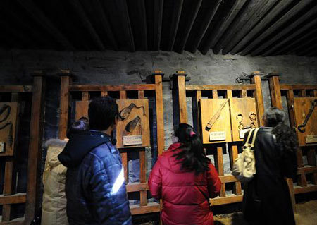 Visitors look at the objects on display at the Zhol City prison site at the foot of the Potala Palace. [Xinhua Photo]