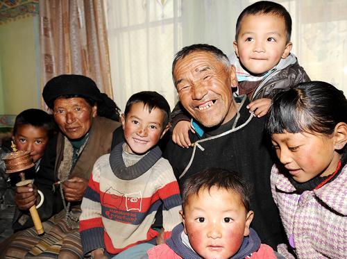 Farmer Losang Qambai(3rd R) of Jigu Village in Maizhokunggar County, southwest China's TAR, and his wife Tang Chong(2nd L) cheer up with their grandchildren on March 21, 2009. [Xinhua photo]