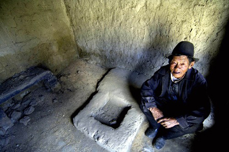 Photo taken on April 19, 2008, shows a dark damp small clay hole -- 'home' for Migmar Dondrup in old days. Inside, a narrow and hard earthen bulge served as the sleeping place for Migmar and his family. [Xinhua photo]