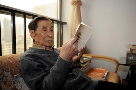 Reporter of Xinhua News Agency Lin Tian is reading at home in Lanzhou, capital of northwest China's Gansu Province on March 22, 2009. [Xinhua photo]
