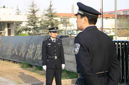 Two policemen stand guard outside the Shijiazhuang Intermediate People's court in Shijiazhuang, capital of north China's Hebei Province, March 26, 2009. Hebei High People's Court conducted the second public trial on tainted milk scandal related cases at the Shijiazhuang Intermediate People's court on Thursday.