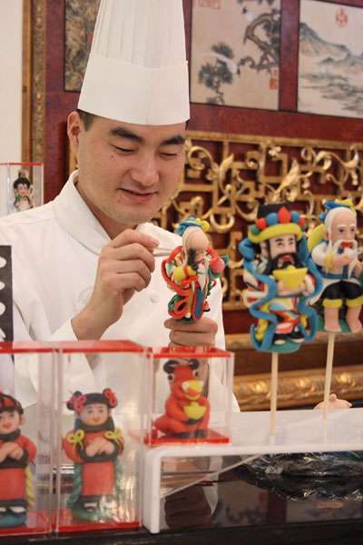 Chef Li Yunfeng is making dough figure in this picture. Exhibiting craftsmanship inherited from his father, Chef Li Yunfeng of China World Hotel's pastry team has lately started to do live demonstrations of Chinese dough figure making at the hotel's Scene a Cafe. [CRI]