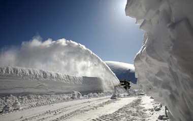 A vehicle removes snow from a highway from Krasnoyarsk to Mongolia after several avalanches on the Kulumys Pass in the Western Sayan Mountains some 620 km (385 miles) south of the Siberian city of Krasnoyarsk March 24, 2009.[Xinhua/Reuters]
