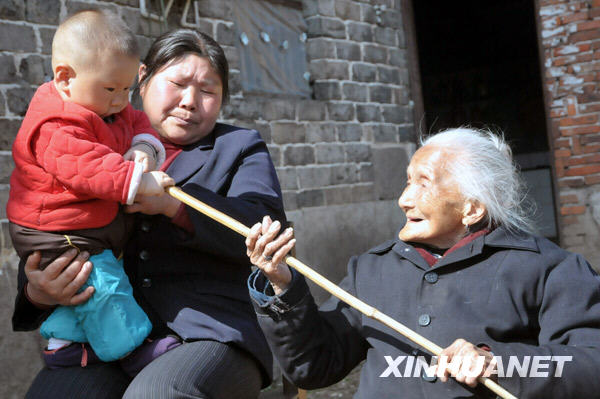 Lin Erde aged 106, enjoys the sunshine with her granddaughter at Zhangkeng Village of De'an County, east China's Jiangxi Province, Mar. 24, 2009. [Li Shibiao/Xinhua]