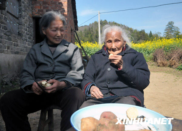 Lin Erde aged 106, eats sweet potato at Zhangkeng Village of De'an County, east China's Jiangxi Province, Mar. 24, 2009.[Li Shibiao/Xinhua]