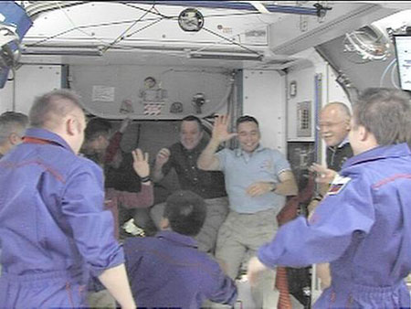 In this image from NASA Television, Wednesday, March 25, 2009, shuttle Discovery astronauts hug with international space station astronauts as they depart the ISS. Space shuttle Discovery has left the international space station. The shuttle undocked from the orbiting outpost Wednesday after eight days. Discovery and its crew of seven are due back Saturday.[Xinhua/AFP]