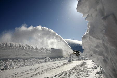 A vehicle removes snow from a highway from Krasnoyarsk to Mongolia after several avalanches on the Kulumys Pass in the Western Sayan Mountains some 620 km (385 miles) south of the Siberian city of Krasnoyarsk March 24, 2009.[Xinhua/Reuters]