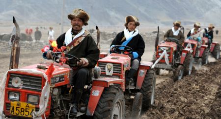 Local villagers drive tractors in a row during a ceremony to mark the start of the spring farming season at Shexing Village, Doilung Deqen County, southwest China's Tibet Autonomous Region, March 15, 2009. [Xinhua photo]