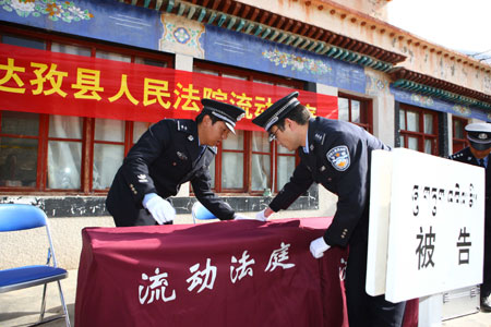 Court policemen prepare for a trial held by the mobile court at a village in Dagze County, southwest China's Tibet Autonomous Region, March 26, 2009. [Gong Bing/Xinhua]