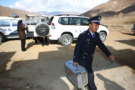 A court policeman prepares for a trial held by the mobile court at a village in Dagze County, southwest China's Tibet Autonomous Region, March 26, 2009.[Gong Bing/Xinhua]