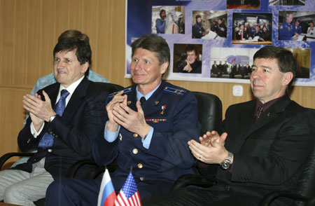 (L-R) U.S. entrepreneur Charles Simonyi, Russian cosmonaut Gennady Padalka and U.S. astronaut Michael Barratt applaud at Baikonur cosmodrome March 25, 2009.[Xinhua/Reuters]