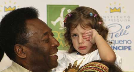 Brazilian soccer legend Pele holds a patient on his arms at the Pequeno Principe (Little Prince) Children's Hospital in the southern Brazilian city of Curitiba March 26, 2009. The Pele Little Prince Institute, patronized by Pele, conducts research into diseases affecting children and treat's around 250,000 patients a year. [Xinhua/Reuters]