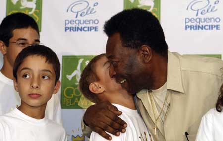 Brazilian soccer legend Pele is greeted by a patient at the Pequeno Principe (Little Prince) Children's Hospital in the southern Brazilian city of Curitiba March 26, 2009. [Xinhua/Reuters]