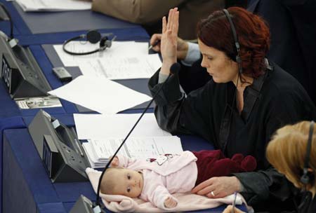 Denmark's member of the European Parliament Hanne Dahl votes as she attends a voting session with her baby at the European Parliament in Strasbourg March 26, 2009.[Xinhua/Reuters]