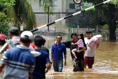 Residents are evacuated from the flood-hit area in the outskirts of Jakarta, Indonesia, March 27, 2009. The dam burst in Ciputat, South Tangerang on the outskirts of Jakarta early Friday morning has caused at least 31 people dead and tens of local residents missing.[Yue Yuewei/Xinhua]