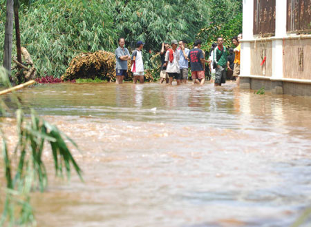 Residents wait for the rescuers at the flood-hit area in the outskirts of Jakarta, Indonesia, March 27, 2009. The dam burst in Ciputat, South Tangerang on the outskirts of Jakarta early Friday morning has caused at least 31 people dead and tens of local residents missing.[Yue Yuewei/Xinhua] 