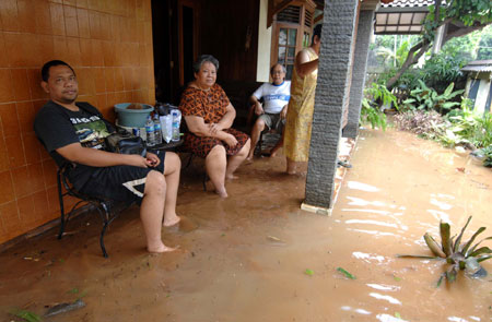 Residents wait for the rescuers at the flood-hit area in the outskirts of Jakarta, Indonesia, March 27, 2009. The dam burst in Ciputat, South Tangerang on the outskirts of Jakarta early Friday morning has caused at least 31 people dead and tens of local residents missing.[Yue Yuewei/Xinhua]