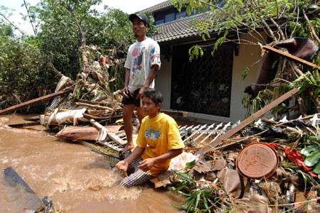 Residents wait for the rescuers at the flood-hit area in the outskirts of Jakarta, Indonesia, March 27, 2009. The dam burst in Ciputat, South Tangerang on the outskirts of Jakarta early Friday morning has caused at least 31 people dead and tens of local residents missing. [Yue Yuewei/Xinhua]