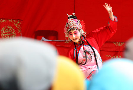 Actors of the Qin Opera Art Troupe of Hami stage performance in a theater of Hami, northwest China's Xinjiang Uygur Autonomous Region, March 18, 2009. [Photo: Xinhua]