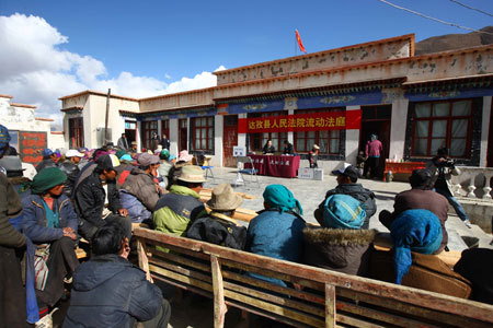 Judge Baizhen (R) attends a trial held by the mobile court at a village in Dagze County, southwest China's Tibet Autonomous Region, March 26, 2009. The court of Dagze County has dispatched the mobile court to villages for years to unload the economic burdens of those who entangled in lawsuits and popularize law knowledge among local residents. [Xinhua photo]