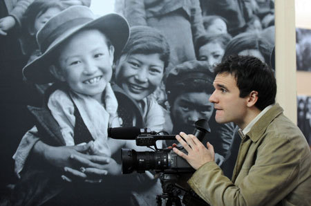 Sergi Vicente, a Spanish TV correspondent, works at the '50th Anniversary of Democratic Reforms in Tibet' Exhibition in Beijing on March 18, 2009. A number of foreign journalists, organized by the Information Department of China's Foreign Ministry, visited the exhibition on Wednesday. [Xinhua photo]