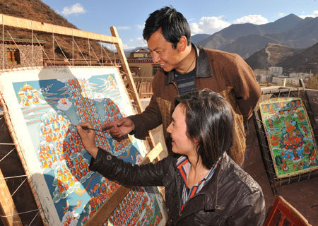 Fourty-one-year-old Cering (rear) teaches his apprentice to draw tangka, traditional Tibetan scroll paintings, in Qamdo, southwest China's Tibet Autonomous Region, March 26, 2009. Cering began to make ritual implements when he was 15. He owns a company, which has taught over 40 handicraft people including three handicapped ones