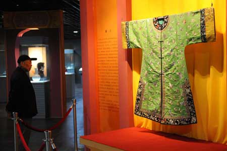 An old visitor views a green dress with embroidery patterned with butterfly dated back to Qing Dynasty (1644-1911 A.D.) at Nanjing Museum in Nanjing, east China&apos;s Jiangsu Province, March 26, 2009. An exhibition featuring articles, such as clothes, shoes, pearls, jades, porcelain, calligraphy, handicrafts, used by imperial concubines of Qing Dynasty was on show.