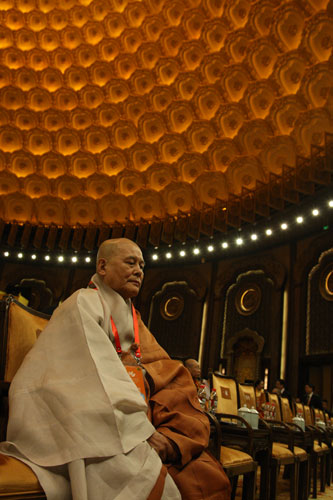 Monk Zhiguan, a distinguished guest at the Second World Buddhist Forum, which opened today (March 28) in Wuxi, Jiangsu Province, sits in the conference hall, also called the Altar, in Fangong Palace, on the city's rural Linshan Mountain.