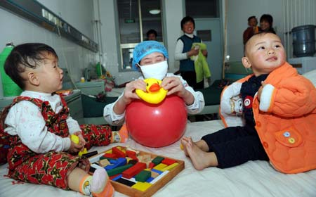 Young hand-foot-mouth disease (HFMD) patients play toys at a hospital in Heze City in east China's Shandong Province, on Mar. 28, 2009. Hand-foot-mouth disease(HFMD) claimed the lives of five babies in a week in Heze City, local authorities said Saturday. Heze city reported 1,734 HFMD cases between Jan. 1 and midnight Friday, according to the city's health bureau. (Xinhua/Fan Changguo)