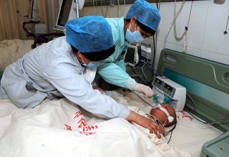 Medical workers take care of a young hand-foot-mouth disease (HFMD) patient Cao Fanglei in Heze City in east China's Shandong Province, on Mar. 28, 2009. Hand-foot-mouth disease (HFMD) claimed the lives of five babies in a week in Heze City, local authorities said Saturday. Heze city reported 1,734 HFMD cases between Jan. 1 and midnight Friday, according to the city's health bureau. (Xinhua/Fan Changguo)