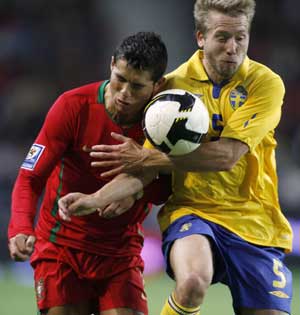 Portugal's Cristiano Ronaldo (L) is challenged by Sweden's Adam Johansson during their 2010 World Cup qualifying soccer match at Dragon stadium in Porto March 28, 2009.
