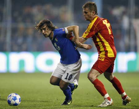 Italy's Andrea Pirlo (L) is challenged by Montenegro's Nikola Pekovic during their 2010 World Cup qualifying soccer match in Podgorica March 28, 2009.