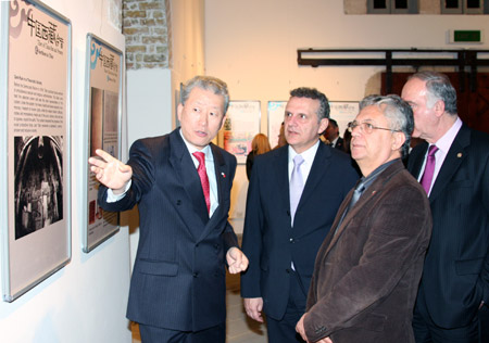 Chinese Ambassador to Cyprus Zhao Yali (1st L) introduces a photo to Mayor of Larnaca Andreas Moyseos (3rd L) in a photo exhibition entitled 'Tibet of China: Past and Present' in Larnaca, Cyprus, March 28, 2009. The exhibition was opened on Friday. 