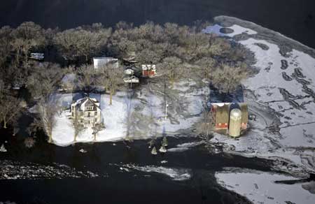 A farm is seen flooded by the Red River south of Fargo, North Dakota March 28, 2009. Hundreds of residents of North Dakota and Minnesota evacuated their homes on Friday as the Red River rose to its highest level in 112 years in the key wheat and sugar beet growing region. 