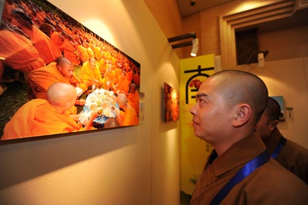 A visitor looks at a photograph during a photo exhibiton on Buddhism during the Second World Buddhist Forum (WBF) in Wuxi, east China's Jiangsu Province, on March 29, 2009.