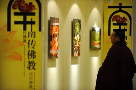 A visitor looks at photographs during a photo exhibiton on Buddhism during the Second World Buddhist Forum (WBF) in Wuxi, east China's Jiangsu Province, on March 29, 2009. 