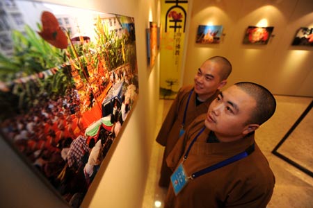 Visitors look at a photograph during a photo exhibiton on Buddhism during the Second World Buddhist Forum (WBF) in Wuxi, east China's Jiangsu Province, on March 29, 2009.