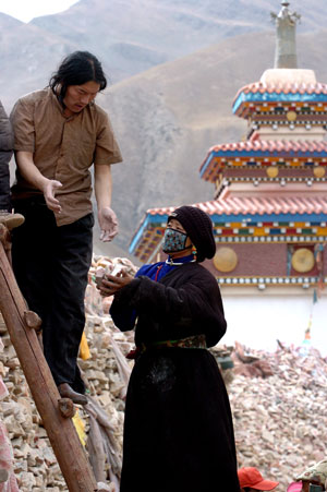 People of Tibetan ethnic group pile Mani stones onto the Jiana Mani Stone Mound in Xinzhai Village, Yushu County, Tibetan Autonomous Prefecture of Yushu, northwest China's Qinghai Province, on March 24, 2009. 