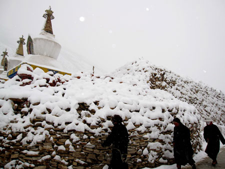 People of Tibetan ethnic group take ritual walks around the Mani Stone Mound in Xinzhai Village, Yushu County, Tibetan Autonomous Prefecture of Yushu, northwest China's Qinghai Province, on March 29, 2009. 