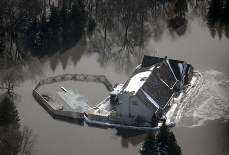 An aerial view shows a home south of Fargo, North Dakota surrounded with sandbags in an attempt to hold out flood water March 29, 2009. 