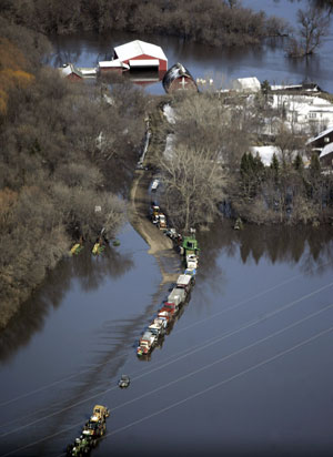 An aerial view shows farm equipment and vehicles parked near a farm that is surrounded by flood waters south of Fargo, North Dakota March 29, 2009.