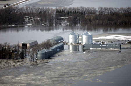 An aerial view shows grain silos on a farm surrounded by flood waters south of Fargo, North Dakota near the Red River of the North March 29, 2009.