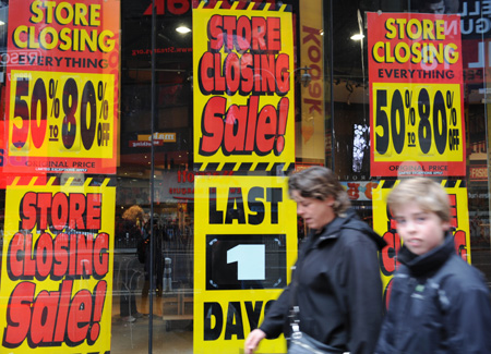 Two persons pass by the Virgin Megastore at Times Square in New York, the United States, March 29, 2009. The store will be closed on Monday. All the other five Virgin Megastores in New York are set to close before this summer. There were once 23 retail locations based in the United States. The physical CD retails witnessed smashing challenge from the digital download music market, the analysts said.[Xinhua]