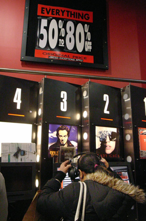 A customer listens to music at the Virgin Megastore in Times Square in New York, the United States, March 28, 2009. The store will be closed on Monday. [Xinhua]